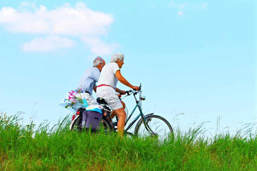person, man, woman, people, couple, elderly, cycling, together, two, side by side, nature, exercise, lifestyle, healthy, motion, destination, sunny day, summer, editorial